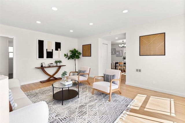 living room with light wood-style flooring, recessed lighting, visible vents, and baseboards