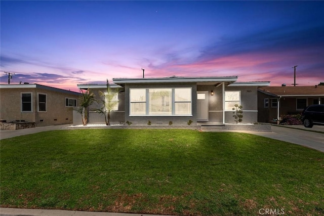 view of front of house with a lawn and stucco siding