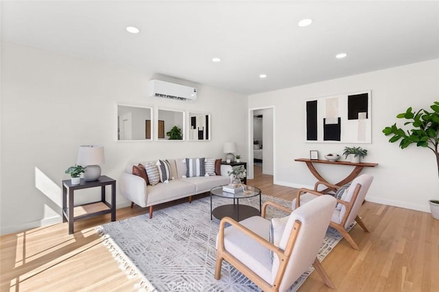 living area featuring recessed lighting, light wood-type flooring, and a wall mounted air conditioner