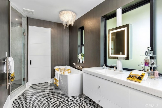 bathroom with vanity, an inviting chandelier, a stall shower, and a freestanding bath