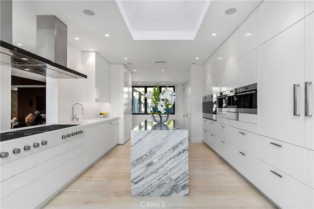 kitchen with ventilation hood, oven, white cooktop, white cabinets, and modern cabinets