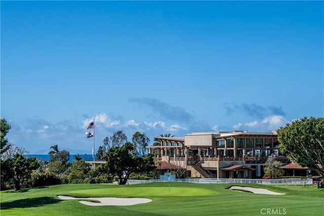 view of community with a yard and view of golf course