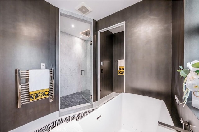 bathroom with visible vents, a soaking tub, and a shower stall