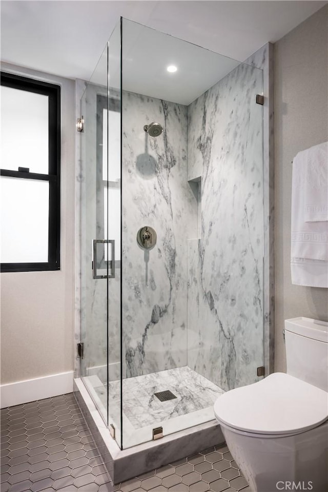 full bathroom with tile patterned flooring, toilet, baseboards, and a marble finish shower