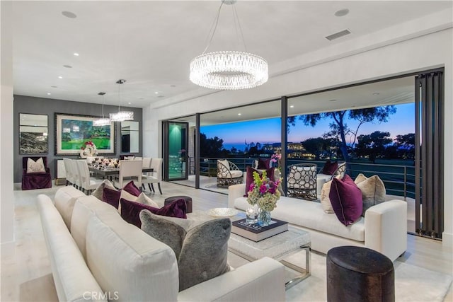 living area featuring a chandelier, visible vents, recessed lighting, and wood finished floors