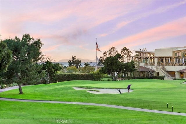 view of community featuring golf course view and a yard