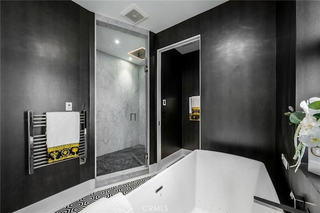 bathroom with a soaking tub, visible vents, and a shower stall