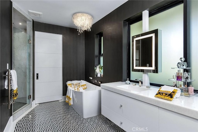 full bathroom featuring a shower stall, a washtub, vanity, and an inviting chandelier