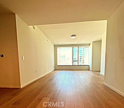 unfurnished room featuring baseboards and hardwood / wood-style floors