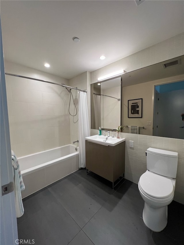 full bath with vanity, visible vents, shower / bath combo with shower curtain, tile walls, and toilet