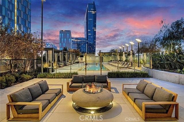 view of patio / terrace featuring a fenced in pool, an outdoor living space with a fire pit, and fence