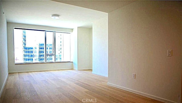 spare room with wood finished floors and baseboards