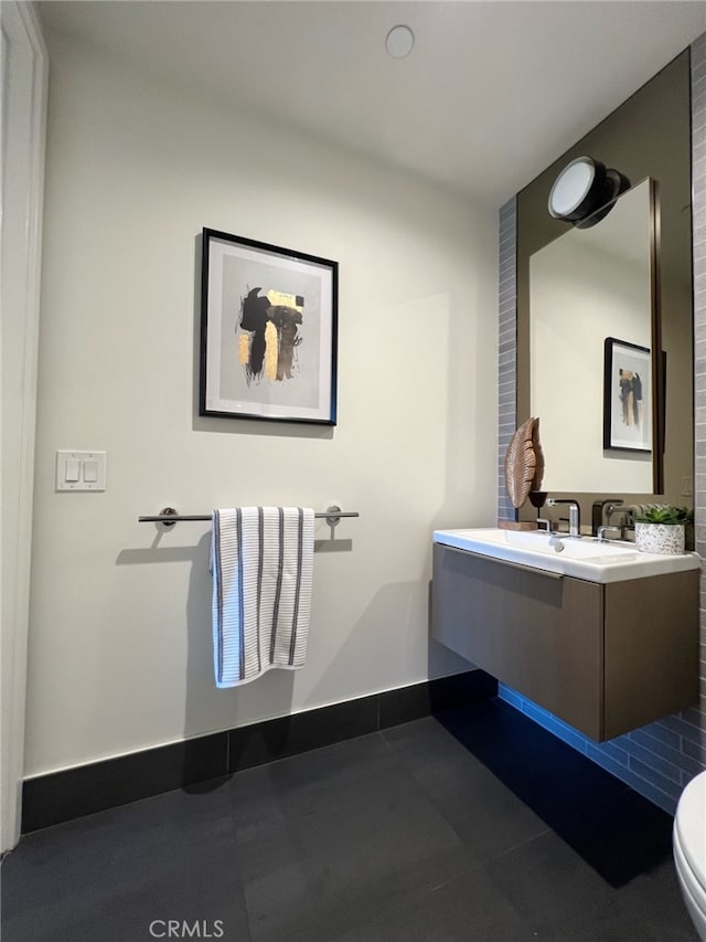 bathroom with tile patterned floors, toilet, vanity, and baseboards