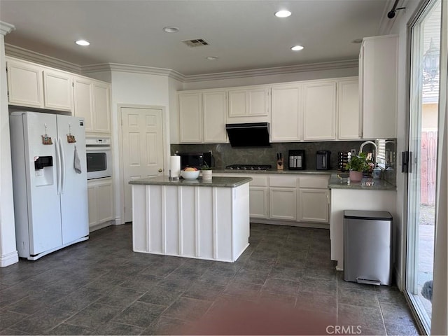 kitchen with visible vents, recessed lighting, white appliances, white cabinets, and decorative backsplash