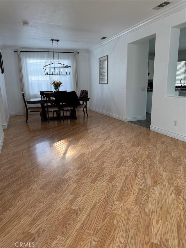 dining space with baseboards, an inviting chandelier, and ornamental molding