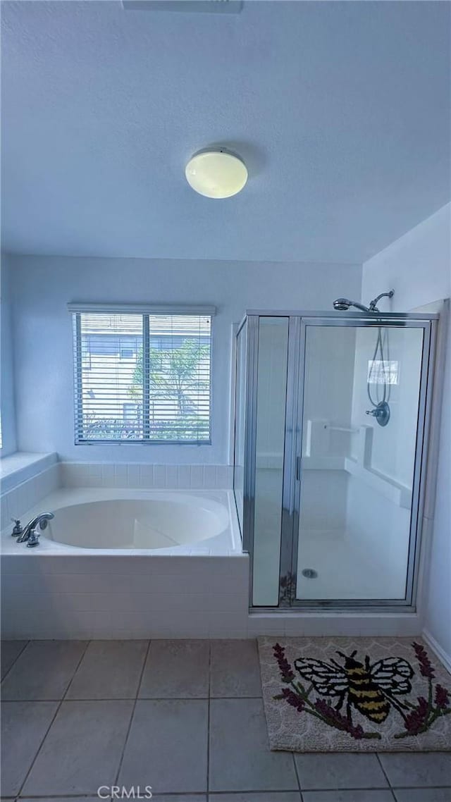 bathroom featuring a shower stall, a garden tub, and tile patterned flooring