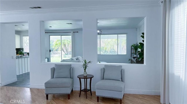sitting room featuring a healthy amount of sunlight, wood finished floors, and visible vents
