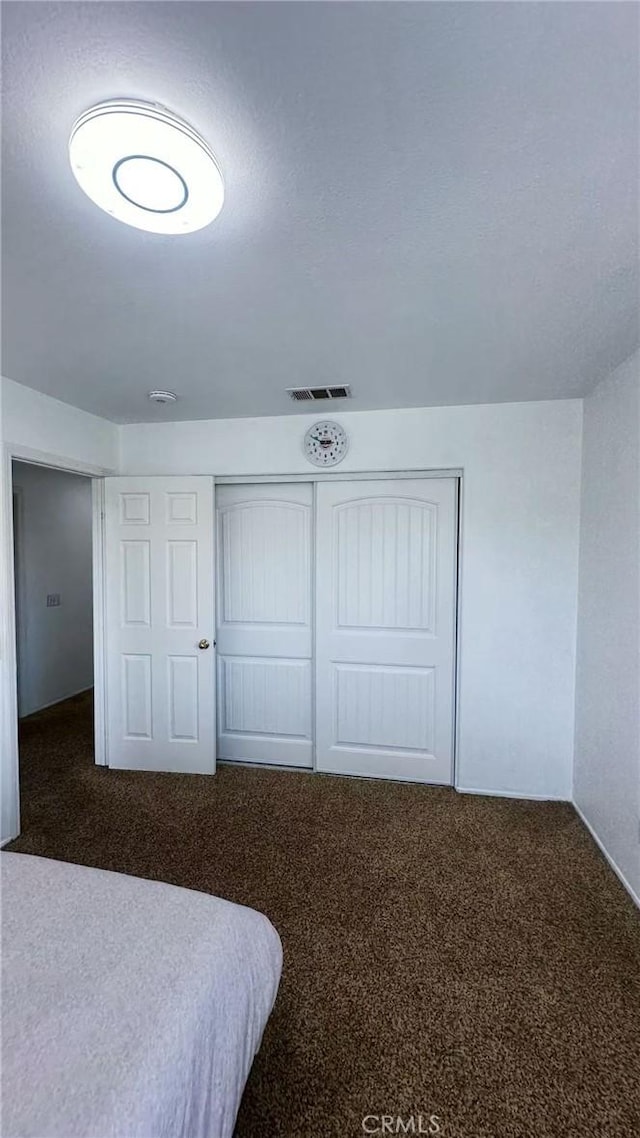 bedroom featuring carpet floors, a closet, and visible vents