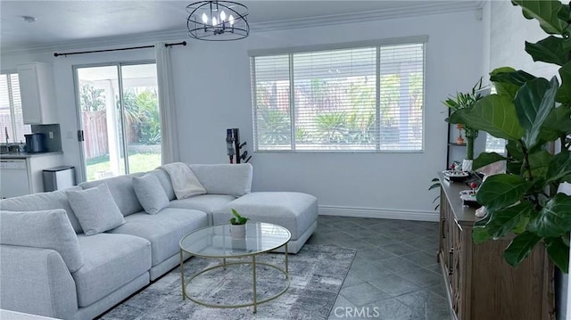 living room with baseboards, a notable chandelier, ornamental molding, and a healthy amount of sunlight