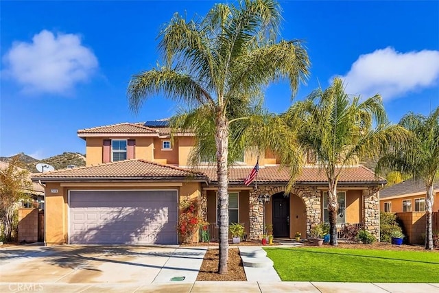 mediterranean / spanish-style house featuring a tile roof, roof mounted solar panels, stucco siding, driveway, and an attached garage