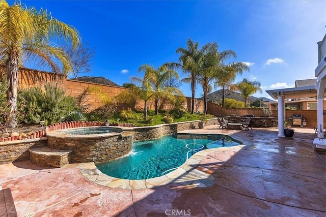 view of pool featuring a patio, a pool with connected hot tub, outdoor dining area, and a fenced backyard