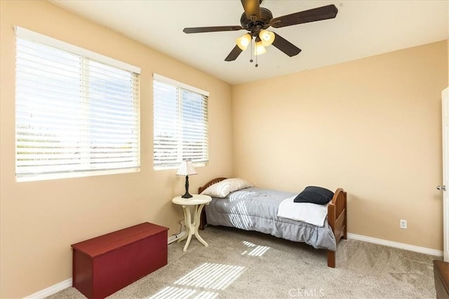 carpeted bedroom featuring baseboards and ceiling fan