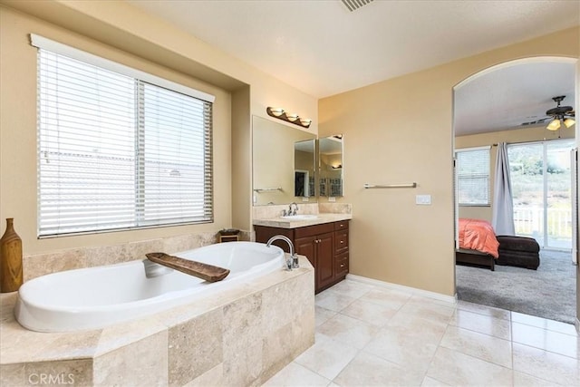 bathroom with tile patterned flooring, vanity, ensuite bathroom, and a garden tub