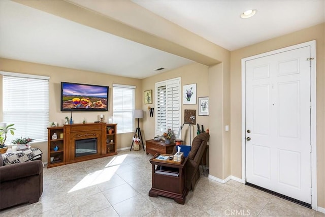 living room featuring light tile patterned floors, visible vents, and baseboards