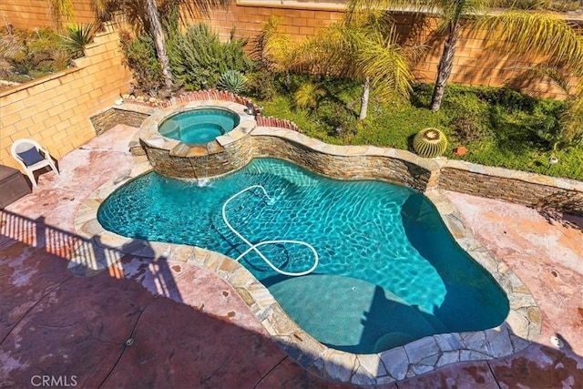 pool featuring an in ground hot tub, fence, and a patio area