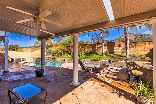 view of patio / terrace with ceiling fan, a fenced backyard, a fenced in pool, and an outdoor fire pit