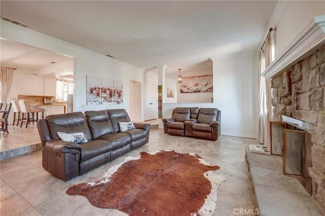 39100 Saddle Ridge Rd, Hemet, CA 92543 - living area with visible vents, a fireplace, baseboards, and ornamental molding
