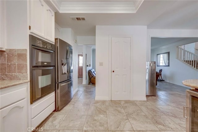 39100 Saddle Ridge Rd, Hemet, CA 92543 - kitchen featuring visible vents, ornamental molding, stainless steel refrigerator with ice dispenser, dobule oven black, and white cabinetry