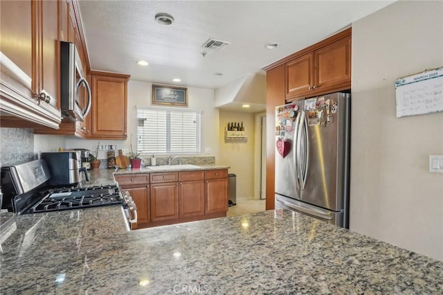 2810 Green River Rd Unit 103, Corona, CA 92882 - kitchen featuring stainless steel appliances, a sink, light stone countertops, recessed lighting, and brown cabinetry