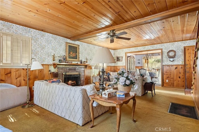 living room with a brick fireplace, wallpapered walls, a wainscoted wall, carpet floors, and wooden ceiling