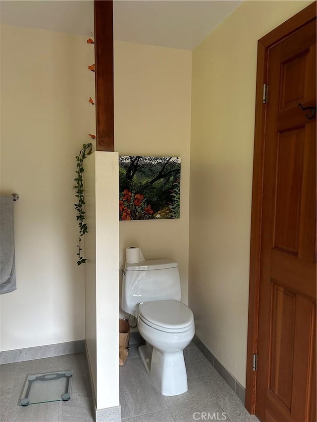 bathroom featuring baseboards and toilet