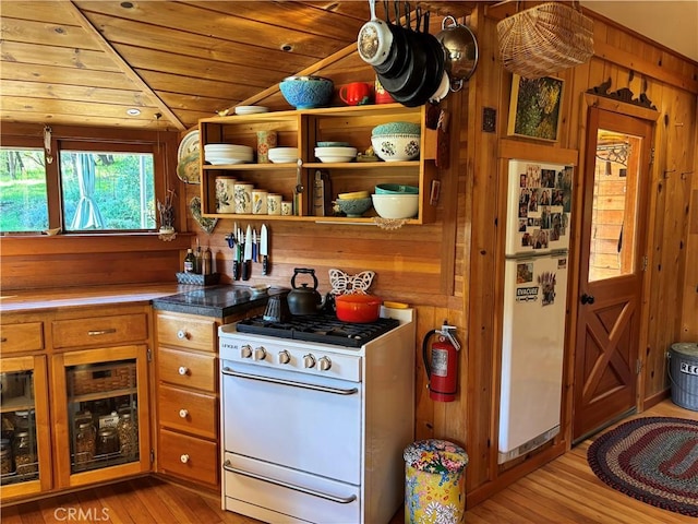 kitchen with brown cabinets, white appliances, wood walls, light wood-style flooring, and wood ceiling