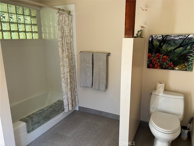 bathroom with toilet, baseboards, and shower / bath combination with curtain
