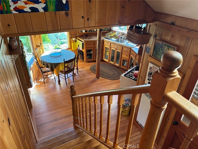 stairway with wooden walls and hardwood / wood-style floors