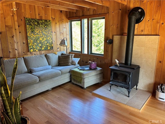 living room featuring wooden walls, wood finished floors, and a wood stove