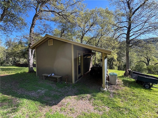 view of property exterior with a lawn and an outbuilding