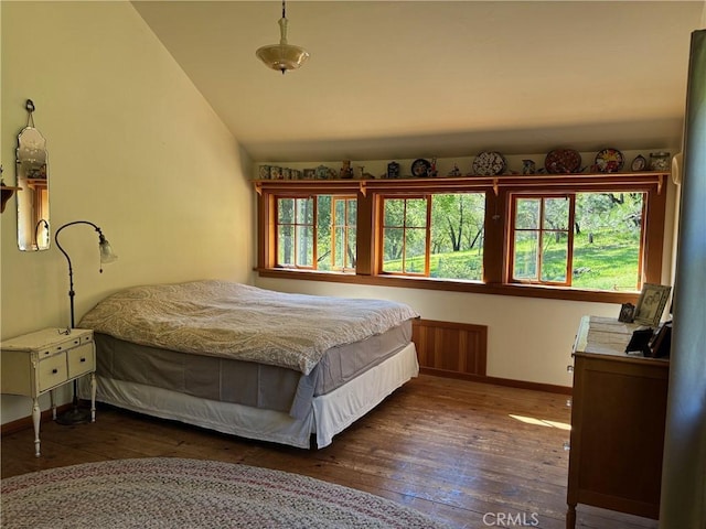 bedroom with baseboards, wood-type flooring, and lofted ceiling