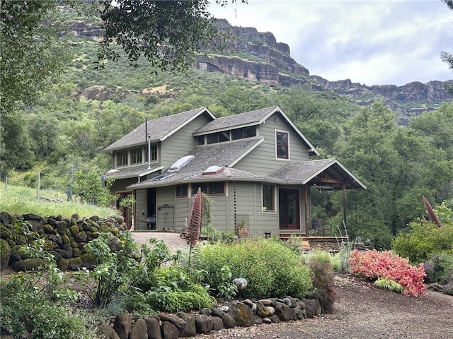 view of front of property with a mountain view and roof with shingles