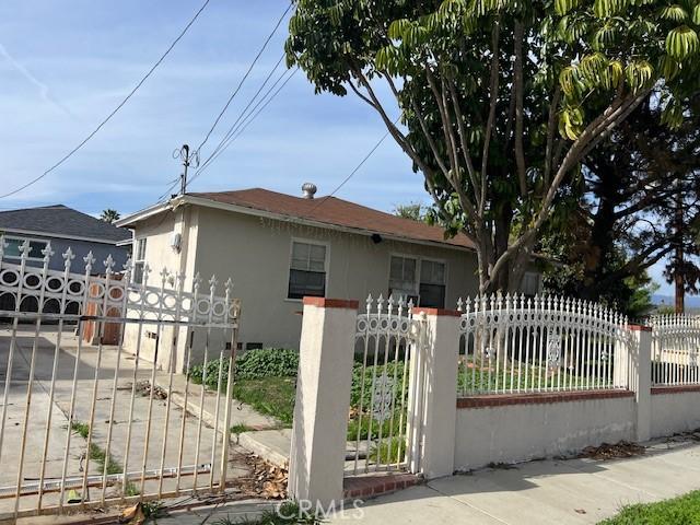 view of front of home featuring a fenced front yard, stucco siding, and a gate