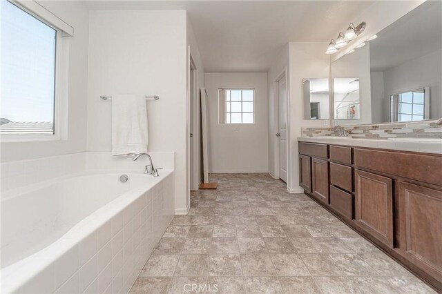 148 Mesquite Ct, Calimesa, CA 92320 - full bathroom with baseboards, a garden tub, backsplash, and vanity