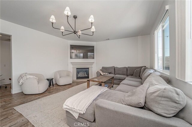 148 Mesquite Ct, Calimesa, CA 92320 - living area featuring a chandelier, wood finished floors, a glass covered fireplace, baseboards, and visible vents
