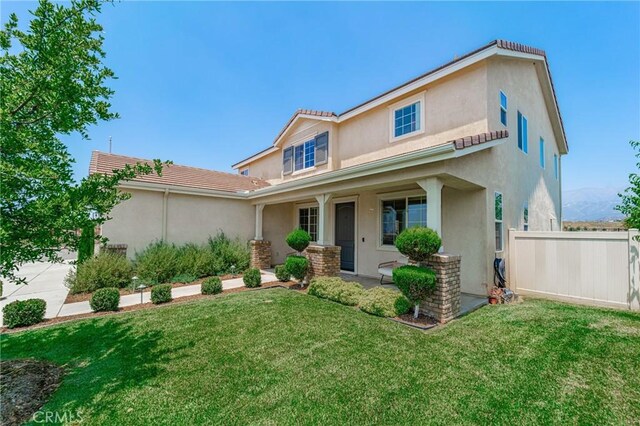 148 Mesquite Ct, Calimesa, CA 92320 - view of front of property with fence, a tiled roof, a front yard, stucco siding, and a porch