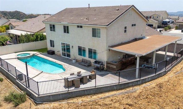 148 Mesquite Ct, Calimesa, CA 92320 - rear view of house with a patio, a fenced backyard, a pool with connected hot tub, and stucco siding