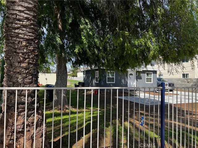 view of property hidden behind natural elements with a fenced front yard