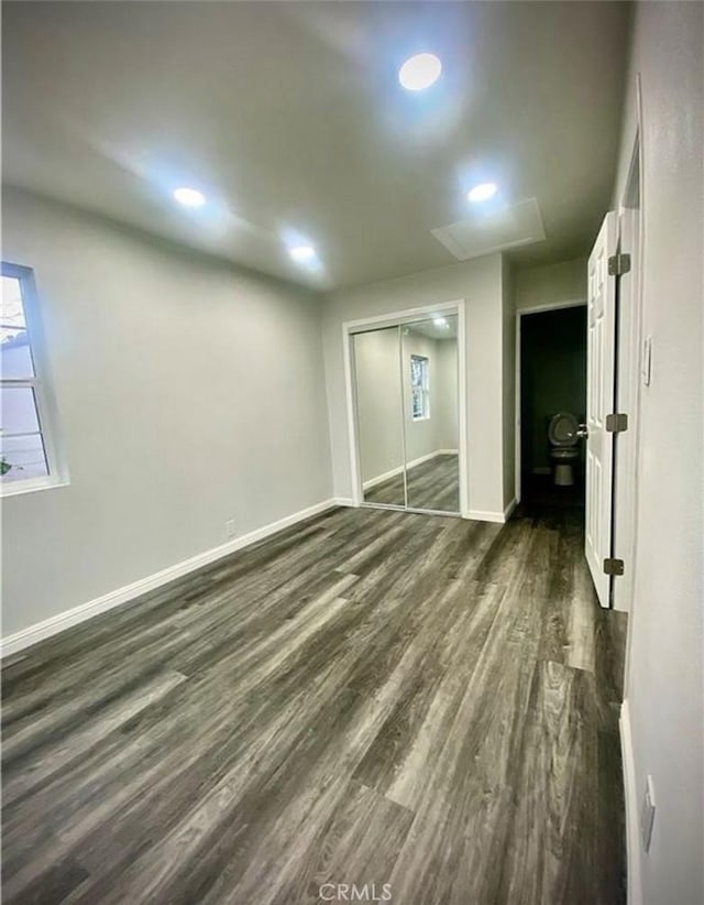 unfurnished bedroom with recessed lighting, baseboards, dark wood-style flooring, and a closet