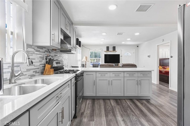 24412 Eucalyptus Ave, Moreno Valley, CA 92553 - kitchen featuring stainless steel range with gas cooktop, a peninsula, a sink, dark wood-type flooring, and recessed lighting